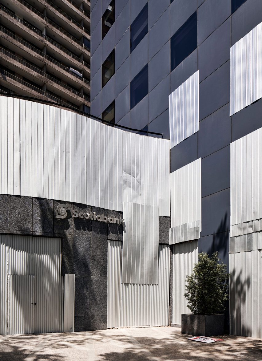 A bank covered in silver metal hoardings 