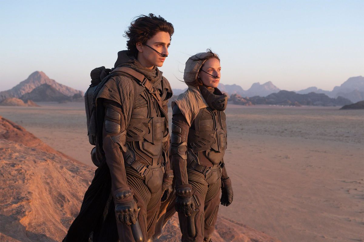 Timothée Chalamet as Paul Atreides and Rebecca Furguson as Lady Jessica Atreides stand in the desert on the set of Denis Villenueve’s Dune.